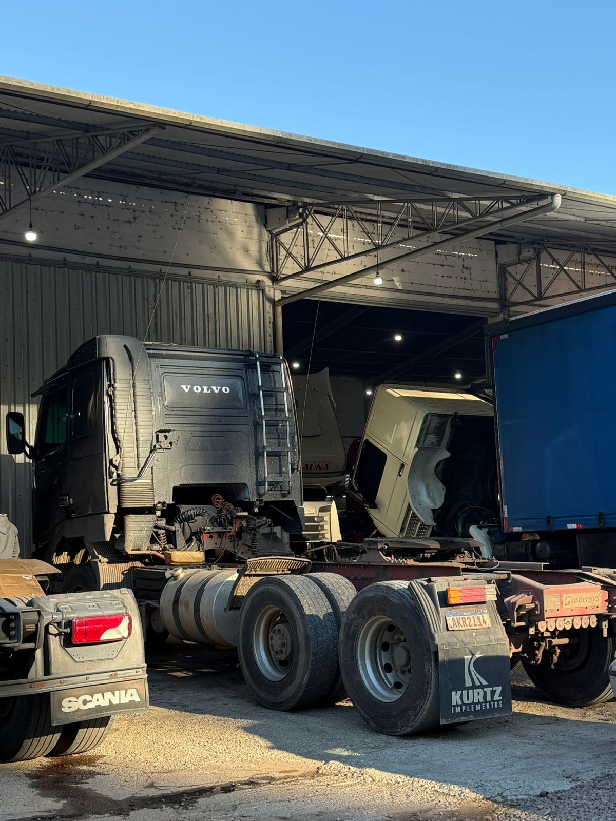 Volvo e Scania na área coberta da oficina